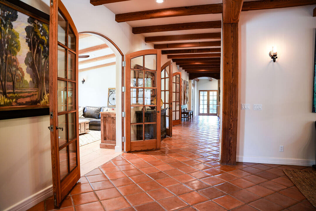 Brown tile hallway with open doors