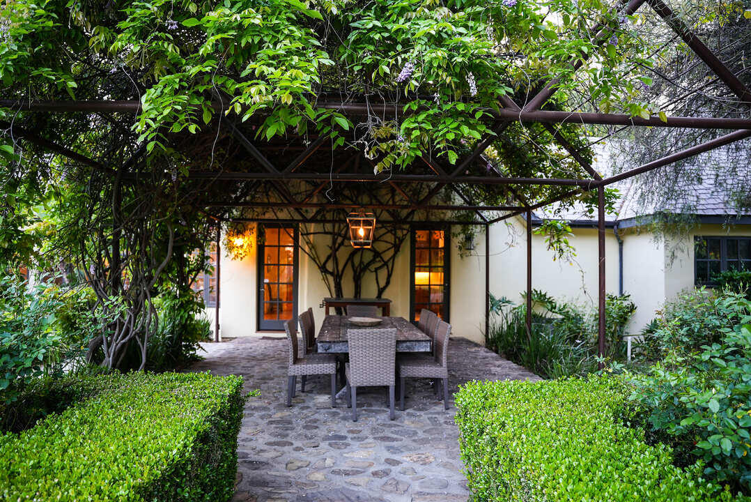 Outdoor dining area with overhead vines