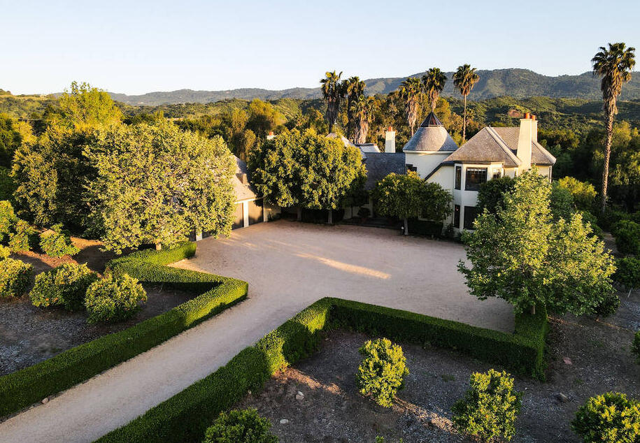 Arial view of front entrance, parking area, garages, and estate